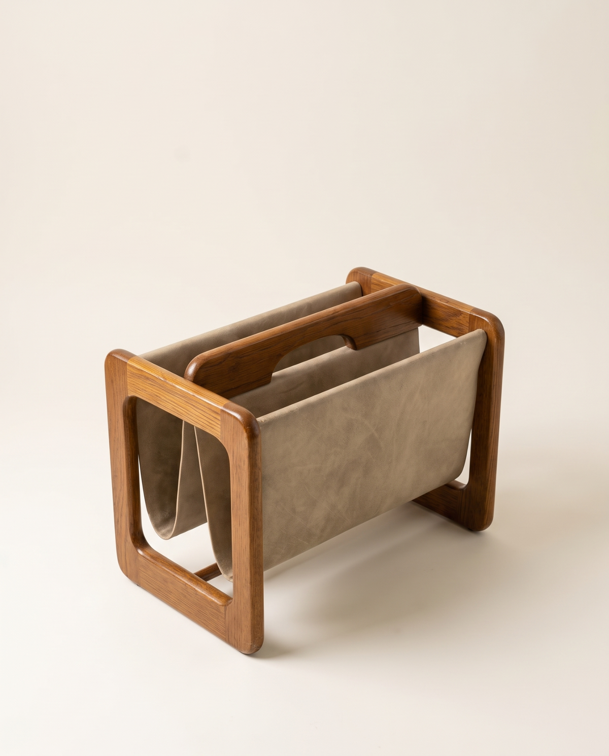 Side view of Danish oak magazine stand with leather sling
