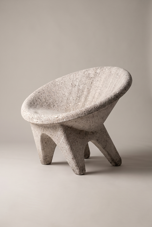A modern concrete stool with a wide, rounded seat and three short legs, shown on a neutral light gray background.